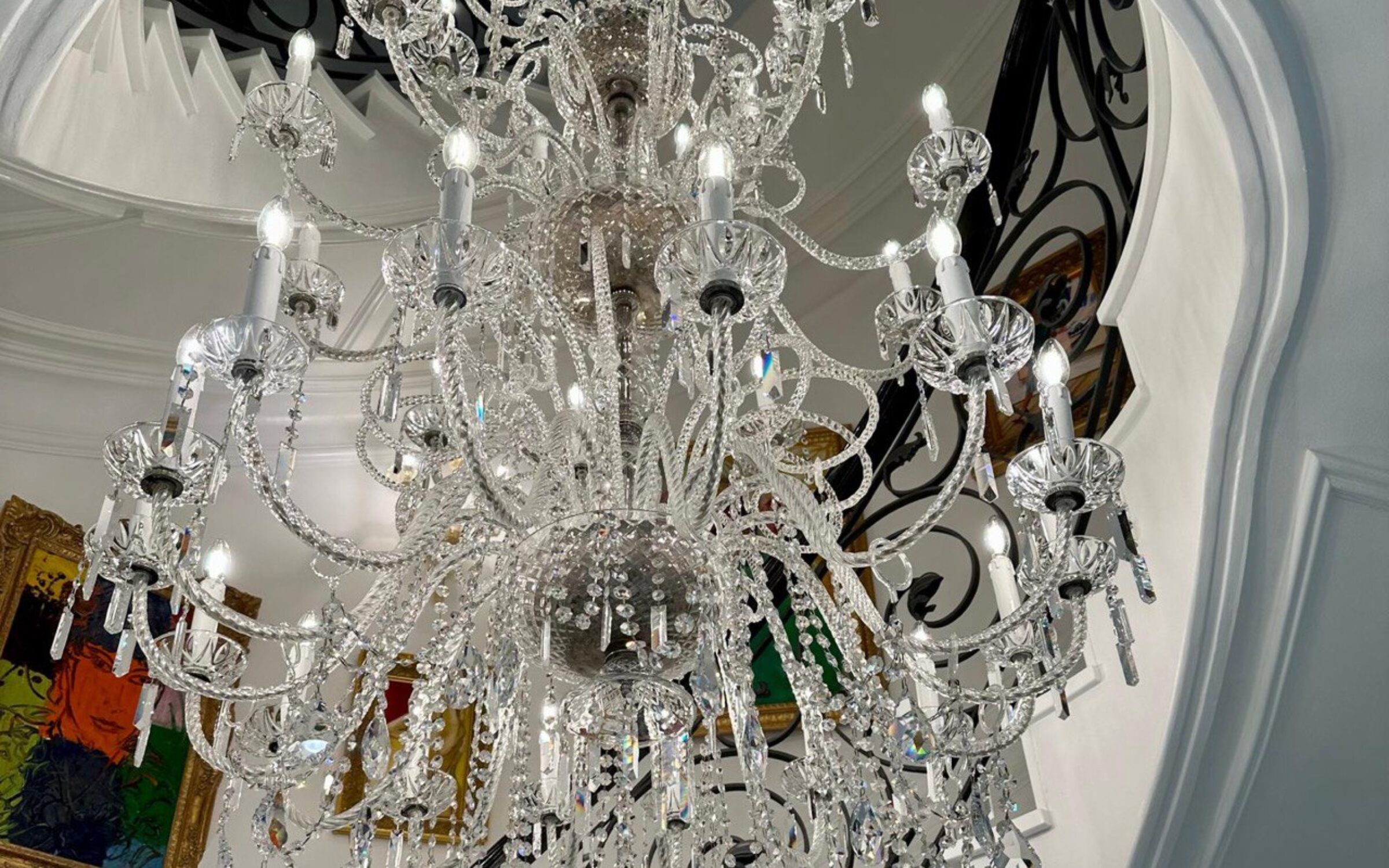 Large crystal chandelier installed in a grand staircase. New York chandelier services.